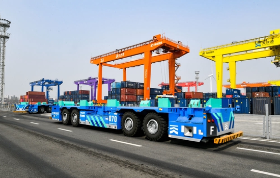 ↑4月9日，在天津港北疆港区C段智能化集装箱码头，智能水平运输机器人在堆场内行驶。
