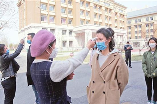 图：天津五中工作人员模拟疫情期间学生入校测体温。 本报记者 谷岳 摄