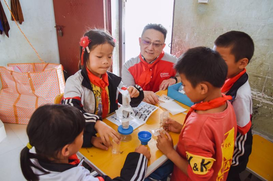吉宝置业中国人力资源部总经理邬渊纹(左三)与学生们共同进行污水净化实验,引导孩子们关注和思考水污染现象,讲述日常生活中环境保护和节约用水知识。
