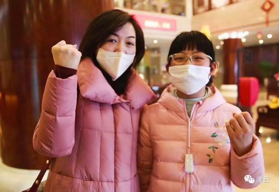 湖北籍游客牛荣与她10岁的女儿面对镜头说：“中国加油！”