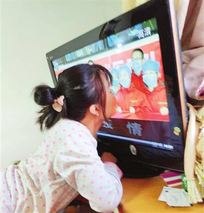 女儿亲吻电视上的妈妈