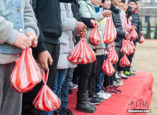 2月26日,浙江温岭石桥头镇中学举行开学典礼,为上学期成绩优秀的学生发放5斤的猪肉作为一等奖学金,三斤作为二等奖学金。 朱海伟 摄 图片来源:视觉中国