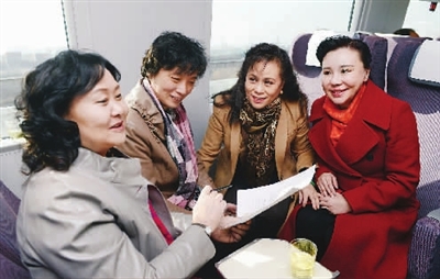 出席全国政协十二届五次会议的住津全国政协委员在赴京城际列车上讨论提案