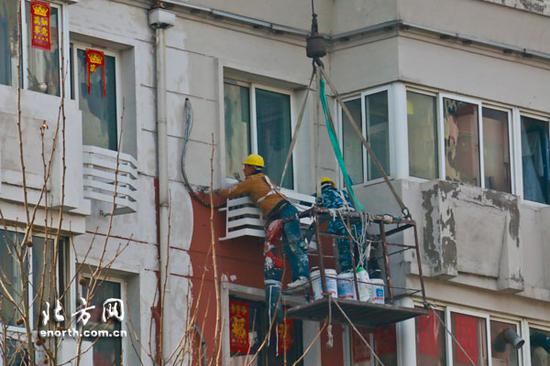 工人重新油漆建筑外墙
