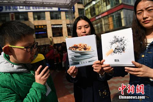 有相关工作人员正在为市民普及垃圾分类知识。