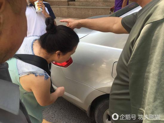 车主向家长指出车上的划痕。