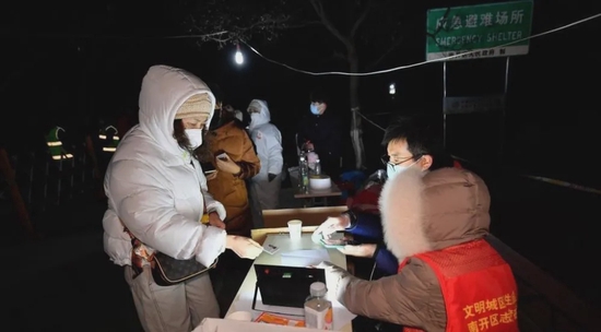 1月12日，在天津市南开区广开街道某核酸检测点，志愿者帮助市民完成核酸采样登记工作。