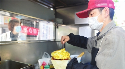在建华里社区复工复产帮扶组安排的临时营业点, 早餐车摊主正在营业。