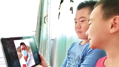 林雨辰和林雨阳聆听父亲支援武汉的故事 本报记者 谷岳 摄