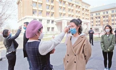 图:天津五中工作人员模拟疫情期间学生入校测体温。 本报记者 谷岳 摄