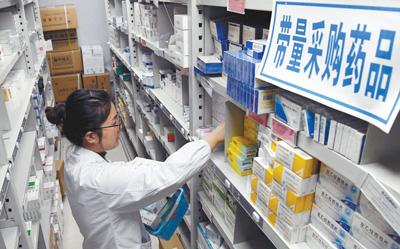 江西南昌大学第二附属医院药房内,医师正在带量采购药品的药架前为患者取药。