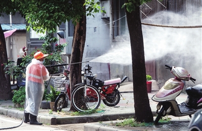 图为5月11日，工作人员在武汉市东西湖区长青街三民小区进行消杀作业。