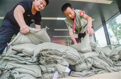 轨道交通运营集团在地铁出入口摆放沙袋以防雨水倒灌。