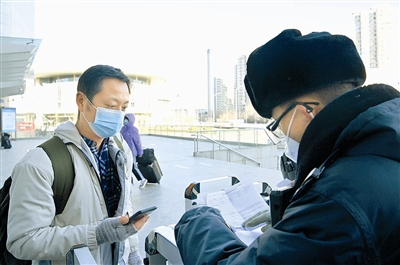 1月17日,工作人员在天津站进站口查验核酸检测报告。 新华社发
