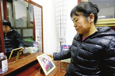 送走丈夫之后,周其香一个人静静地拿起女儿的照片端详