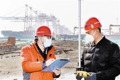 图为工作人员在天津港北疆港区C段智能化集装箱码头工程施工现场进行测量。本报记者 刘乃文摄