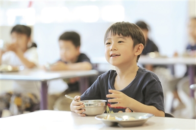 萌娃们在幼儿园里开心就餐 