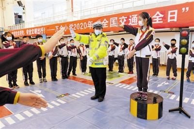 图为近日，本市万全小学对学生们开展交通安全教育，交警以及汽车企业志愿者通过演示、指导、模拟等方式向学生传递交通安全知识。