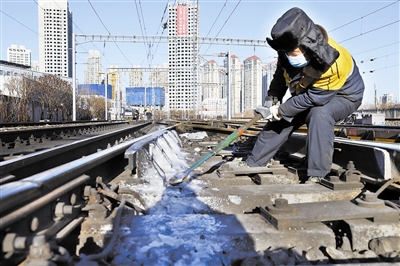 铁路职工对道岔结冰地段进行清理作业。