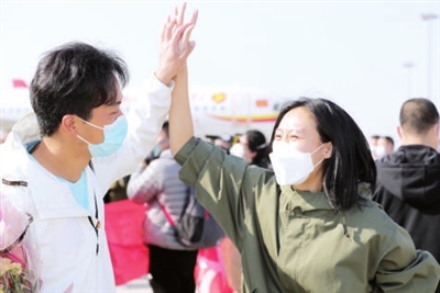 本组图片:天津医疗队队员乘机抵达天津滨海国际机场,受到热烈欢迎。