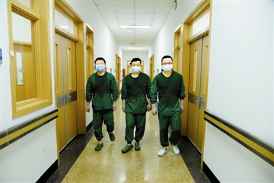 2月1日，从海河医院红区走出的韩骏锋（左）、曹传武（中）、李建国三位重症一队医生，汗水已浸透了他们贴身的刷手服。