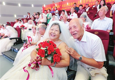81岁的陈子周老人(前排右)和77岁的老伴儿庞凤岭(前排左)结婚已有55周年。如今,穿上漂亮的婚纱和礼服补拍婚纱照,老两口圆了多年的梦。