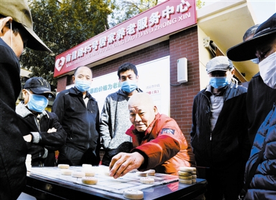 在南昌路45号居家养老服务中心,老人们聚在一起下棋。
