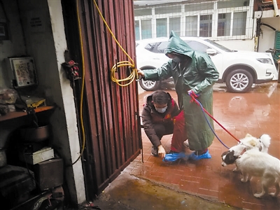 看到经常有居民不戴口罩,杨龙明自费买了口罩和鞋套。下雨时,他还会为老人穿上鞋套。