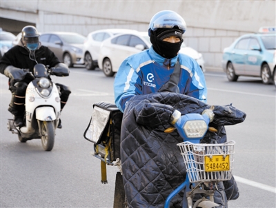 外卖小哥顶风送餐。
