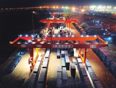 搭乘长春—天津铁海联运班列的粮食货物27日晚抵达天津港，正在进行火车接卸作业，准备连夜装船。