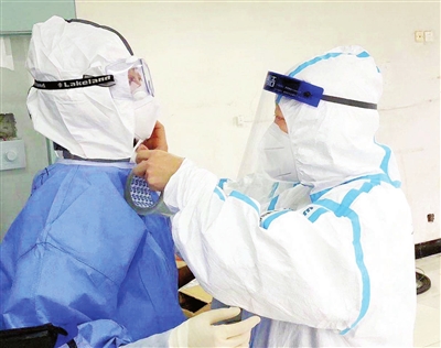 王莹在武钢二院检查“红区”医护人员的防护服。