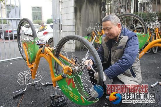 夏英雄正在给送来维修的自行车换胎。