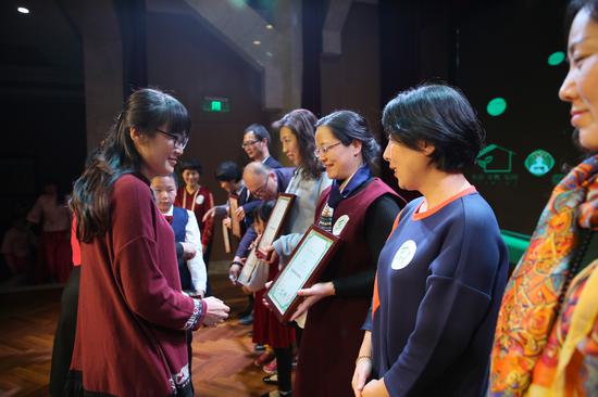 北京市妇联家庭儿童部副部长刘焕春(左)为优秀参演单位颁奖