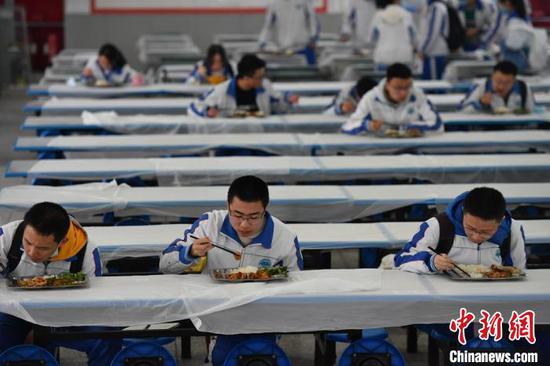 成都七中(高新校区)学生在食堂单向间隔就餐。 张浪 摄