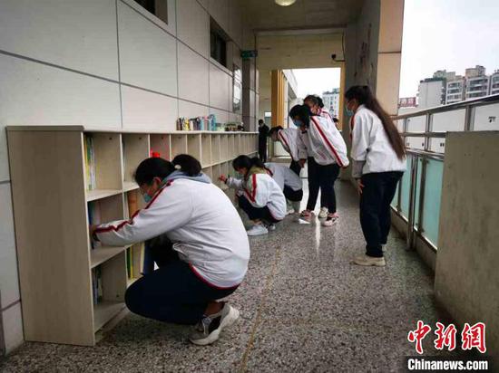 课间,成都三中学生在走廊书柜里找书,准备下一节课 。 单鹏 摄