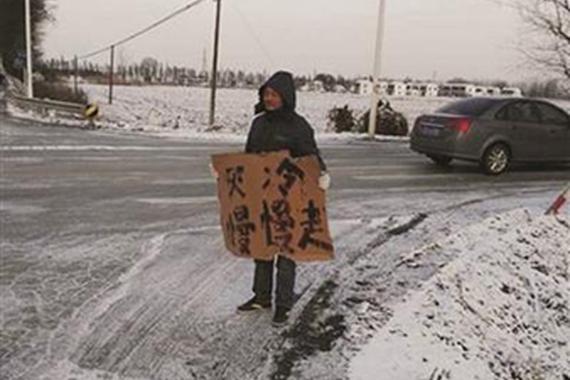 小伙寒潮中举牌两小时 提醒司机注意安全