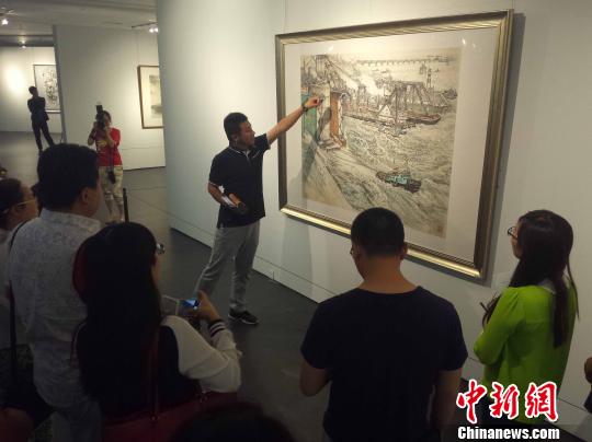 山东美术馆策展人张膑向参观者介绍画作。　胡健 摄