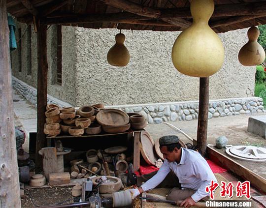 　　达坂城古镇有一个木亭式的木制品加工坊，新疆维吾尔族民间木器艺人阿卜杜黑力力麦图孜正在制作木碗。　史玉江　摄