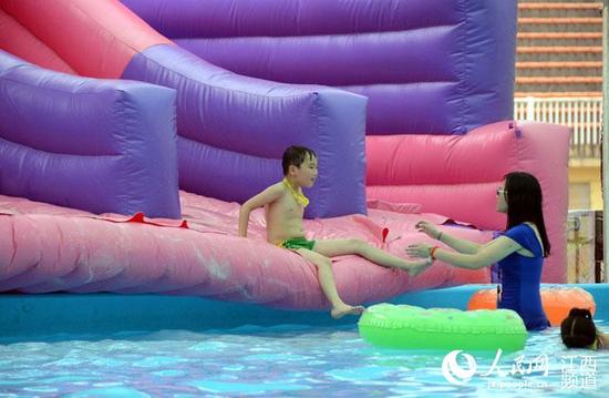 南昌八一体育场内的儿童游乐园内小朋友在泳池游泳纳凉。