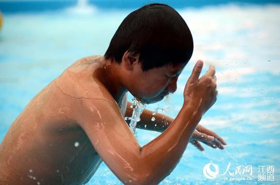 南昌八一体育场内的儿童游乐园内小朋友在泳池游泳纳凉。