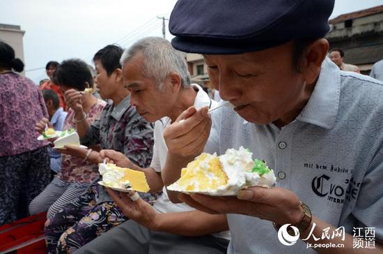 村民们共同分享定制的爱心蛋糕。