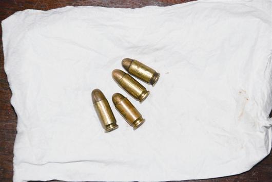 图为：警察缴获的手枪、子弹和毒品