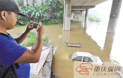 洪水淹没停放在北滨路忠恕沱码头的轿车。