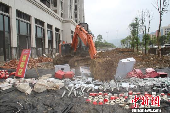 图为挖掘机碾压伪劣消防水袋和消火栓箱。