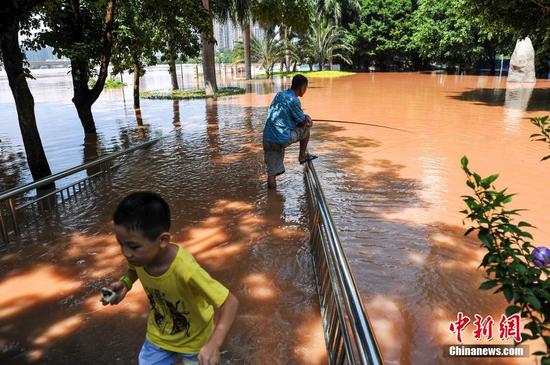 南宁迎洪峰公园被淹 市民水中淡定钓鱼