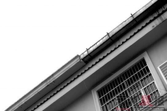 9月24日，长沙南二环新开铺附近的沿街门面，三楼外墙的装饰条（上图所示位置）跌落，砸中停放在路边的小车，跌落的装饰条材质为泡沫和水泥。组图/记者陈勇