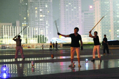 9月25日晚，长沙市贺龙体育馆东广场，十多名市民在一起打陀螺。     记者  田超  摄