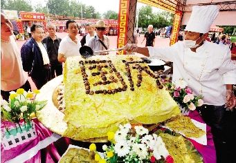 昨日，汉口江滩美食节开幕，一企业现场做出巨型豆皮。本报记者 孙辰 摄