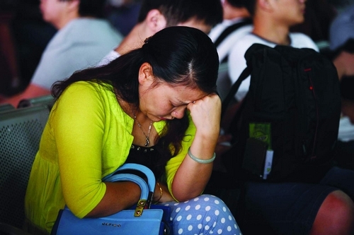 9月30日，长沙汽车西站候车大厅挤满了人，一位候车的女士神情疲惫。图/记者朱辉峰