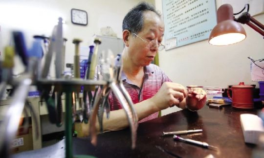 汉口江汉路附近的眼镜加工间里,老师傅在校正眼镜框。